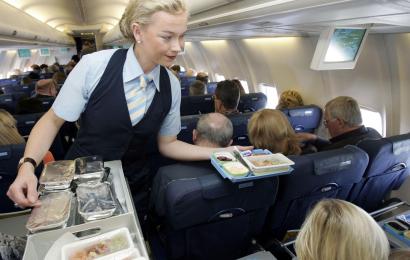 Flight attendant hands out food to passengers imageBROKER/REX